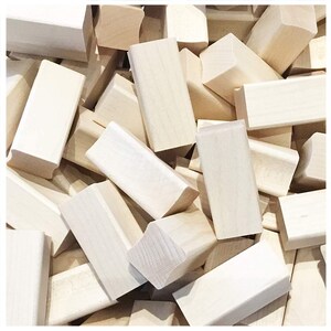 May include: A large pile of unfinished, natural wood blocks. The blocks are various sizes and shapes, with some having rounded edges.