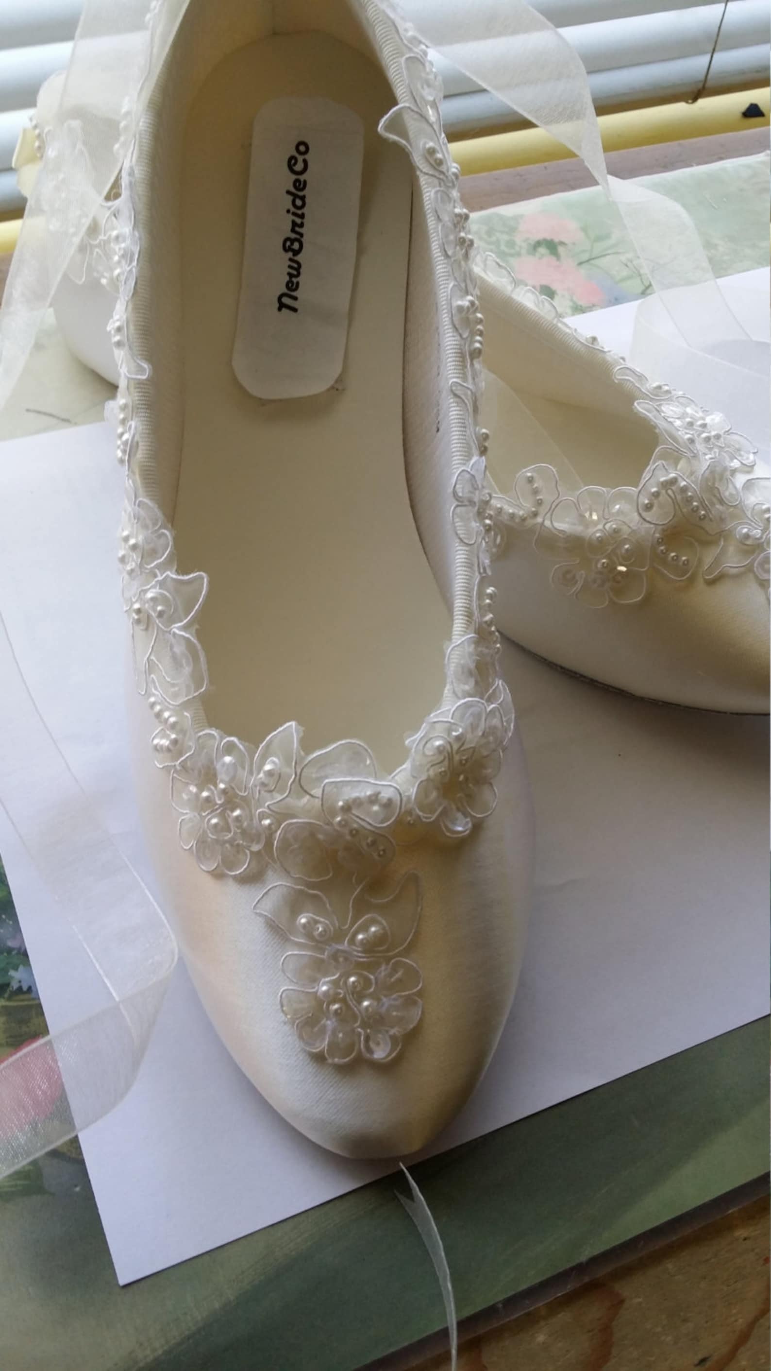 brides satin wedding flats white silver edging appliqué, white satin ballet style slippers, lace flowers all along edge. romanti