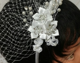 May include: White bridal headband with a veil, pearl and rhinestone embellishments, and a floral design.
