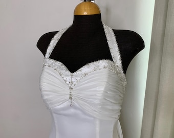 Vestido de novia de gasa blanca con cuello halter, talla 8, de Moonlight, con espalda baja y cola, ideal para una boda en la playa o una escapada romántica.