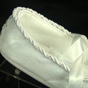 May include: White satin slipper with a white satin ribbon and a beaded trim.