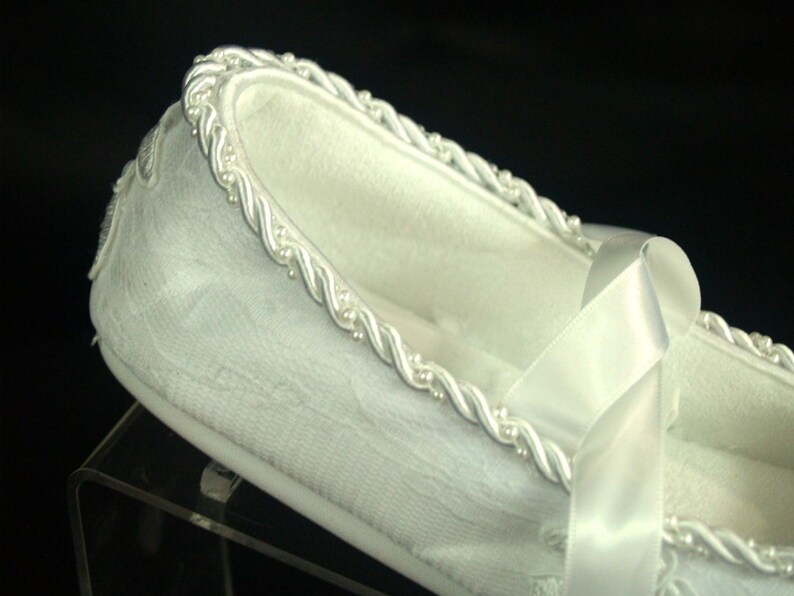 May include: White satin slipper with a white satin ribbon and a beaded trim.