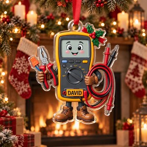 May include: A Christmas ornament shaped like a yellow digital multimeter with a smiling face, holding pliers and electrical test leads. The device features the name DAVID printed on the front, brown work boots, and a red ribbon for hanging.