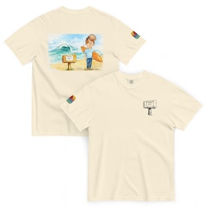 May include: Cream-colored t-shirts with a watercolor illustration of a surfer on the back and a small sign on the front. The surfer is holding a surfboard on a beach with a large wave. The sign on the front says "animal party".
