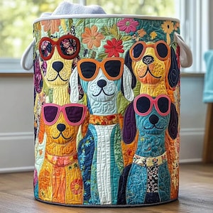May include: A round, quilted laundry hamper featuring a colorful design of dogs wearing sunglasses. The dogs are in various colors, with floral and patterned clothing. The hamper has white handles and a floral trim.