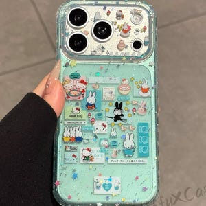 Puede incluir: Funda de tel&eacute;fono transparente con fondo verde menta y purpurina. La funda presenta ilustraciones de dibujos animados de Hello Kitty y personajes de Miffy. El texto "OU ARE CUTE" y texto japon&eacute;s son visibles.