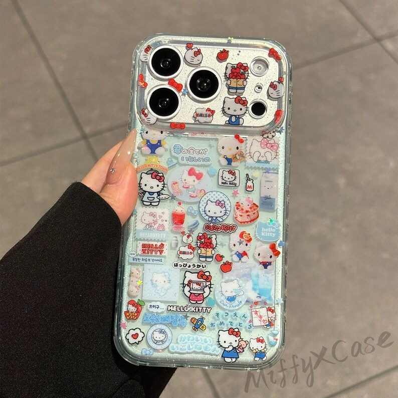Puede incluir: Funda de tel&eacute;fono transparente decorada con pegatinas del personaje Hello Kitty. Las pegatinas presentan a Hello Kitty en varias poses, junto con otros gr&aacute;ficos tem&aacute;ticos. La funda tiene un borde transparente y un fondo azul claro.
