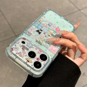 Puede incluir: Una funda transparente para tel&eacute;fono con un fondo de purpurina azul claro y varios dise&ntilde;os de personajes de dibujos animados. La funda tiene un borde transparente y tres c&iacute;rculos negros para la c&aacute;mara. La funda est&aacute; decorada con personajes de dibujos animados rosas, blancos y amarillos.