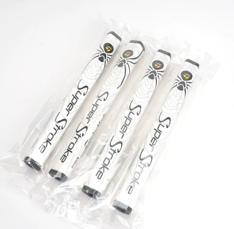 Pu&ograve; includere: Quattro impugnature per putter da golf bianche con la scritta "Super Stroke" in nero. Ogni impugnatura presenta un disegno a ragnatela con una grafica di ragno. Le impugnature sono confezionate in un sacchetto di plastica trasparente.