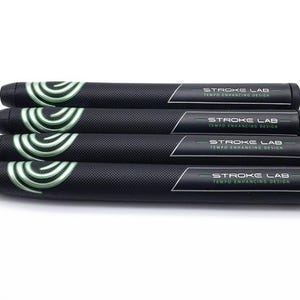 May include: Four black golf club grips with a textured surface. Each grip has a white and green swirl design on one end and the text "STROKE LAB TEMPO ENHANCING DESIGN" on the other end.