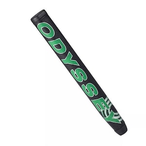 May include: Black golf putter grip with the word "ODYSSEY" in green block letters. The grip has a textured surface and a black end cap. The word "ODYSSEY" is repeated on the grip.