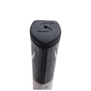 Puede incluir: Primer plano de un grip de palo de golf negro con una superficie texturizada y un eje blanco. El grip presenta un logotipo "S" estilizado en el extremo. El grip tiene un patr&oacute;n de peque&ntilde;as formas repetidas.