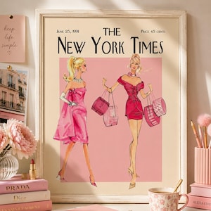 Könnte beinhalten: Ein gerahmter Druck der Titelseite der Zeitung The New York Times vom 25. Juni 1991. Die Illustration zeigt zwei Figuren in rosa Kleidern, die Einkaufstaschen vor einem hellrosa Hintergrund tragen, alles in einem weißen Holzrahmen.