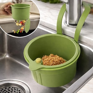 May include: A green sink strainer with a handle, designed to hang over the sink. The strainer holds cooked noodles. A smaller, detachable green container with a handle is shown with food scraps being emptied into the sink.