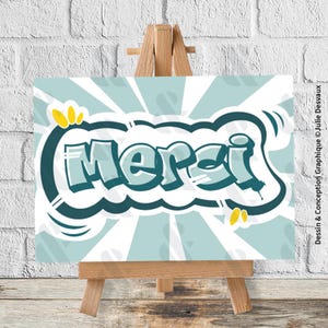 Peut inclure: Impression graphique sur chevalet en bois. Le mot "Merci" est écrit en style graffiti, avec un contour bleu foncé, sur fond bleu clair et lignes radiales blanches. Des touches de jaune complètent le design.