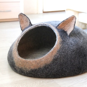 Small dog bed from natural wool in black brown with natural white. Pet bed with ears.