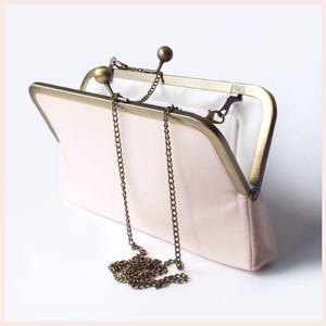pale pink wedding clutch bag with Antique Brass tone kisslock frame and shoulder chain has white lining
