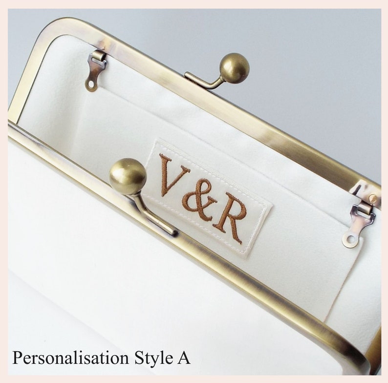 example of personalised monogram embroidered in bronze thread on ivory silk label sewn onto interior pocket of wedding clutch bag with antique brass tone kisslock frame