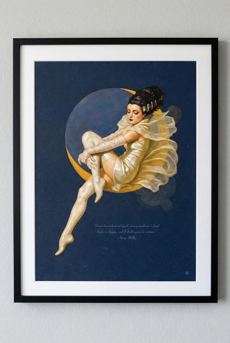 Puede incluir: Impresi&oacute;n art&iacute;stica enmarcada que representa a una mujer sentada con un vestido y guantes color crema, descansando sobre una luna creciente sobre un fondo azul oscuro. Incluye una cita de Mary Shelley.