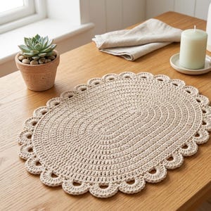 May include: An oval-shaped beige crochet placemat featuring a textured, concentric stitch pattern and a decorative scalloped edge. The placemat is crafted from yarn and displays a consistent, neutral color throughout its entire woven surface.