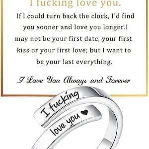 May include: A silver-toned metal ring with an open, adjustable band design. The ring features the engraved black text 'I fucking love you' followed by a heart symbol. It is displayed against a white card with a gold heart and text.
