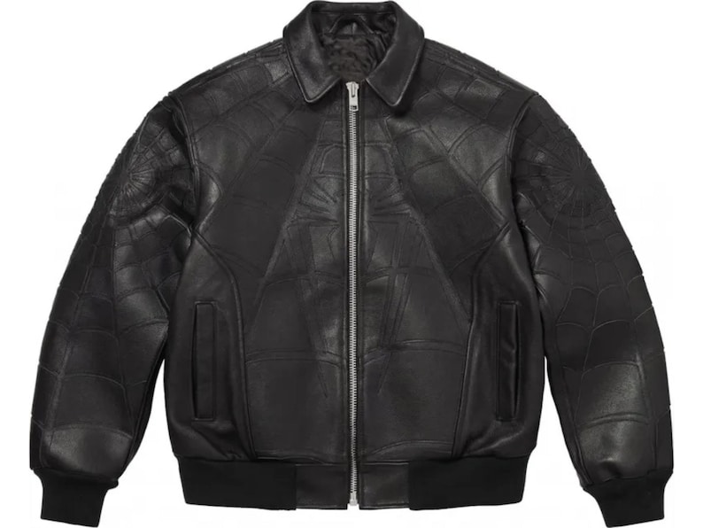 K&ouml;nnte beinhalten: Eine schwarze Leder-Bomberjacke mit einem tonalen, gepr&auml;gten Spinnennetz-Muster auf der Vorderseite und den &Auml;rmeln. Die Jacke verf&uuml;gt &uuml;ber einen klassischen Kragen, einen silberfarbenen Frontrei&szlig;verschluss aus Metall, zwei Seitentaschen sowie schwarze Rippstrickb&uuml;ndchen an &Auml;rmeln und Saum.