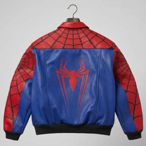 May include: A blue and red leather jacket with a Spider-Man design. The jacket features a red spiderweb pattern on the shoulders and sleeves, a blue torso with a red spider emblem, and a black hem and cuffs.