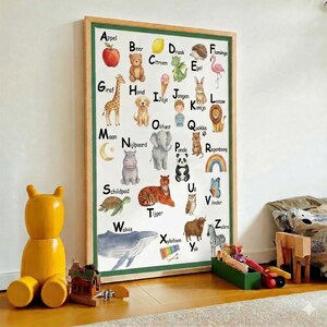 May include: A framed alphabet chart featuring colorful illustrations of animals and objects, each corresponding to a letter. The chart includes a red apple, a teddy bear, a giraffe, a dog, and a whale.
