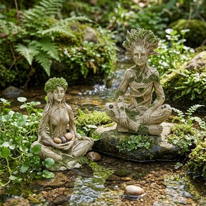 May include: Two serene statues of figures with tree-like features, seated in a meditative pose. One holds stones, the other sits atop a turtle. The statues are tan with green moss accents, set in a natural, outdoor environment.