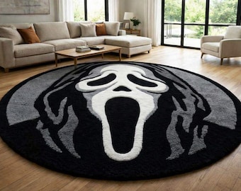 May include: A circular area rug featuring a high-contrast graphic design of the Ghostface mask. The rug is rendered in a palette of black, white, and various shades of gray, with the iconic elongated face centered prominently on the round surface.