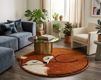 May include: A round, plush area rug featuring a stylized, sleeping fox design in shades of burnt orange, cream, and black. The rug has a thick, textured pile and is shaped to follow the outline of the curled-up fox, creating a soft floor accent.