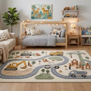 May include: A rectangular area rug featuring a light cream background with a gray winding road pattern, yellow construction vehicles, green trees, and small wooden figures, placed in a room with a sofa, bed, and children's furniture.