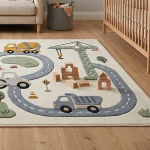 May include: A rectangular area rug featuring a construction site theme with a light cream background. The design includes a winding gray road, a yellow cement mixer, a blue dump truck, a green crane, and various wooden block structures.