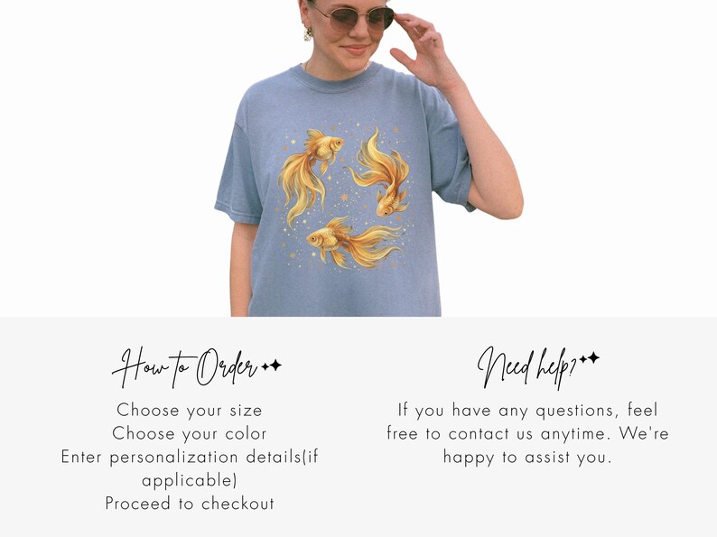 May include: A light blue t-shirt featuring a watercolor design of three golden goldfish with flowing fins and small gold accents. The shirt is a short-sleeved, crew neck style.