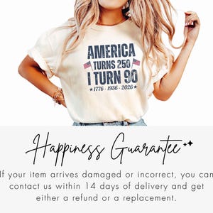 May include: Cream-colored t-shirt with the text "AMERICA TURNS 250 / I TURN 90" in navy blue, with two small American flags. The shirt also includes the years 1776-1936-2026. The shirt is a casual style.