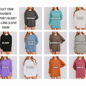 K&ouml;nnte beinhalten: Eine Auswahl an lang&auml;rmeligen Shirts in verschiedenen Farben, darunter Schwarz, Blau und Wei&szlig;. Das Bild zeigt die Comfort Colors 6014 Long Sleeve Shade Kollektion, wobei jedes Shirt mit seinem Farbnamen beschriftet ist. Der Text "SELECT YOUR FAVORITE COMFORT COLORS" steht oben.