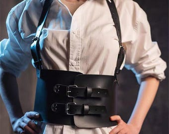 Cinto corset de couro preto com alças para os ombros.