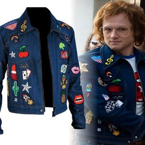 May include: A dark blue denim jacket adorned with colorful patches, including a musical note, a rainbow, a cherry, and a lipstick. The jacket has a classic collar and a zipper closure. The patches add a unique and artistic flair to the garment.