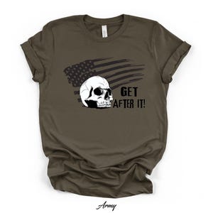 Puede incluir: Camiseta verde militar con un diseño de calavera blanca, una bandera americana negra y el texto "GET AFTER IT!". La palabra "Army" está impresa en cursiva en la parte inferior.