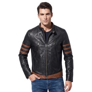 May include: A black leather jacket featuring a stand-up collar, a central silver zipper, and two vertical zippered chest pockets. The sleeves are accented with three horizontal brown leather stripes, and the hem is finished with a brown leather band.