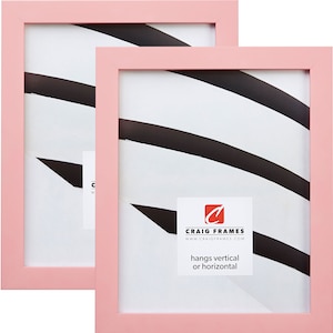 May include: Two pink picture frames with a white mat and a black and white abstract design inside. The frames are made by Craig Frames and can be hung vertically or horizontally.