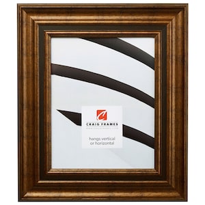 May include: A brown wood picture frame with a gold-toned finish. The frame has a simple, classic design with a slightly raised edge. The frame is designed to hang vertically or horizontally. "Craig Frames" and the website address are printed on a white label inside the frame.