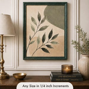 May include: A framed botanical print with a dark green frame. The artwork features watercolor-style leaves and abstract shapes in shades of green and beige. The text at the bottom reads "Any Size in 1/4 inch Increments up to 30" x 40".
