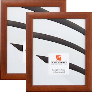 May include: Two brown wood picture frames with a white mat and a black and white abstract design. The frames are 11x14 inches and can hang vertically or horizontally. The frames are made by Craig Frames.
