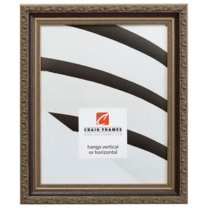 May include: A brown wood picture frame with an ornate design. The frame is made of wood and has a gold finish. The frame is suitable for hanging both vertically and horizontally. The text on the frame reads "Craig Frames" and "www.craigframes.com". The text also reads "hangs vertical or horizontal".
