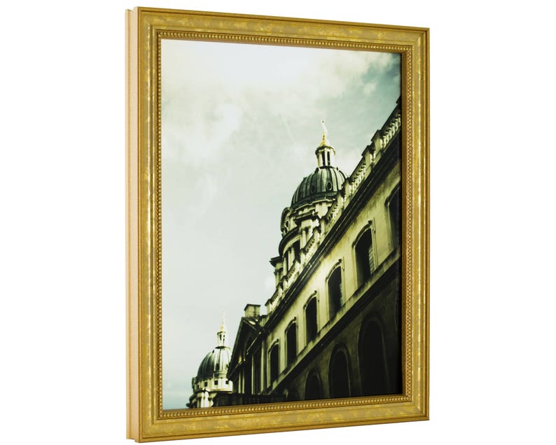 May include: A framed photograph of a building with a dome-shaped roof. The building is made of stone and has a lot of windows. The photo is in a gold frame with a decorative border.