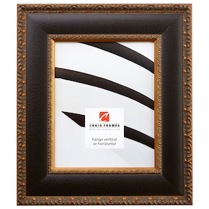 May include: A brown picture frame with a gold ornate border. The frame is made of wood and has a matte finish. The frame is designed to hang vertically or horizontally. The text "CRAIG FRAMES" and "www.craigframes.com" is printed on the mat.