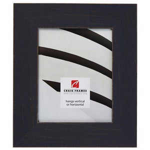 May include: A black wood picture frame with a distressed finish. The frame is 11x14 inches and hangs vertically or horizontally. The frame is made by Craig Frames.