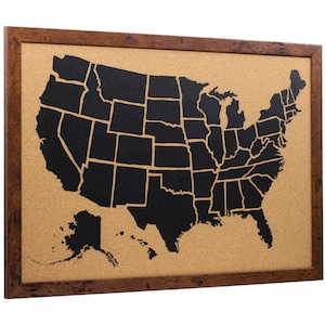 May include: A corkboard with a black outline of the United States map, showing the individual states. The corkboard is framed in brown wood.