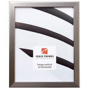 May include: A rectangular silver-colored picture frame with a brushed metal finish. The frame has a white interior with a black and white abstract design. The frame includes a white label with the text "Craig Frames" and "hangs vertical or horizontal".